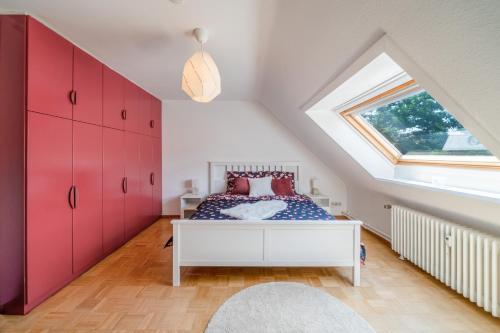 sypialnia na poddaszu z czerwonymi szafkami i łóżkiem w obiekcie Mitten im Herzen von Hannover / Familienfreundlich / 80m² w Hanowerze