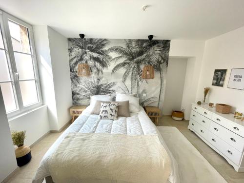 a bedroom with a bed and palm trees mural at La Maison Pinot Noir in Gevrey-Chambertin