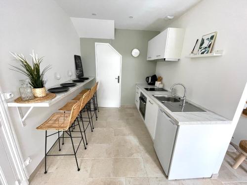 a kitchen with a sink and a counter with stools at La Maison Pinot Noir in Gevrey-Chambertin