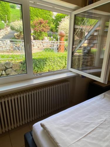 a room with two windows and a bed in front of it at Gästehaus und Ferienwohnung Bächle in Bad Peterstal