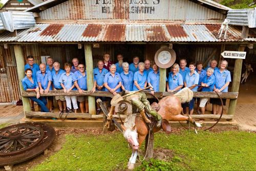 a group of people in blue shirts posing in front of a building at Mareeba Motor Inn in Mareeba