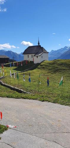 a group of flags on a field with a house at Lorli in Bettmeralp