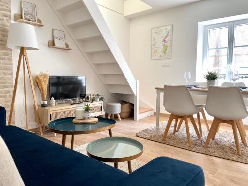 een woonkamer met een blauwe bank en een tafel bij La Maison Pinot Noir in Gevrey-Chambertin
