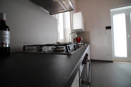 a kitchen with a stove and a bottle of wine at Dimora Savarino Marzamemi Suites with pool in Marzamemi