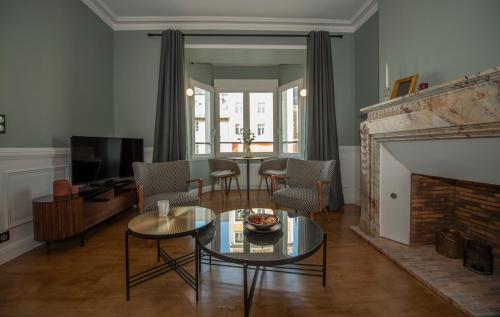 Una sala de estar con una mesa y una chimenea. en La Villa du Sillon, en Saint-Malo