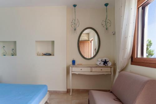 a bedroom with a mirror and a bed and a table at Villa Nostalgia Lentas No1 in Léntas