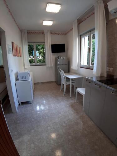 a kitchen with a table and a table and chairs at Villa Ca'Bianca in Bibione