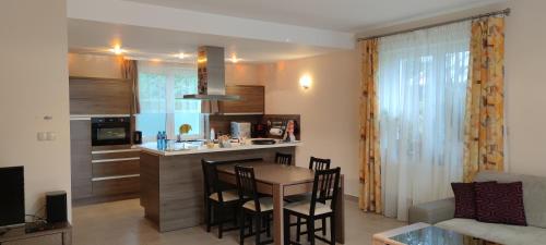 a kitchen and living room with a table and chairs at Dom na Kaszubach nad Jeziorem Gowidlińskim - całoroczny in Sulęczyno