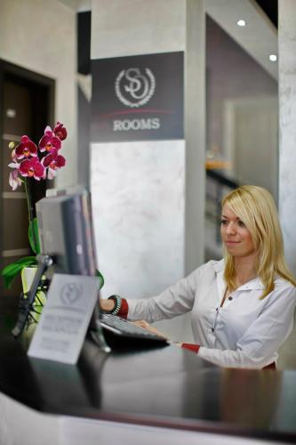 a woman sitting at a desk in front of a computer at Side One Design Hotel Garni in Belgrade