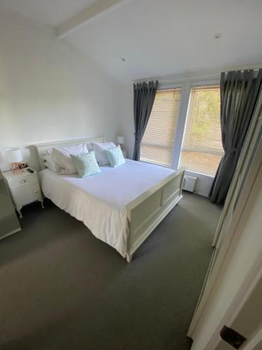 a bedroom with a large bed and a large window at Lovely Lodge in private grounds with enviable view in Hordle