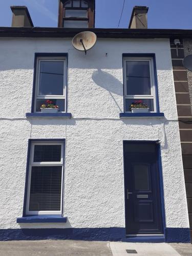 a white building with two windows and a door at Tirchonaill Townhouse in Donegal