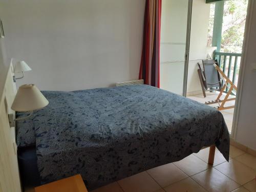 - une chambre avec un lit et un balcon dans l'établissement Appartement cosy, à Moliets-et-Maa