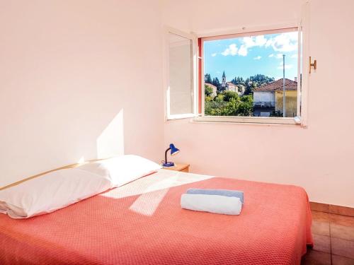 a white bedroom with a bed and a window at Apartmani Miljak Trpanj in Trpanj