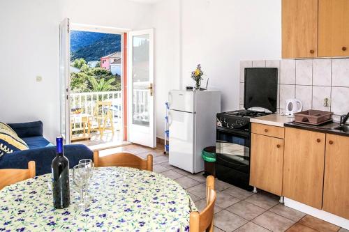 eine Küche mit einem Tisch und einer Flasche Wein darauf in der Unterkunft Apartmani Miljak Trpanj in Trpanj
