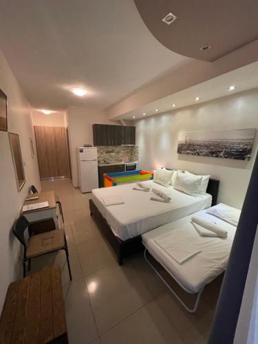 una stanza con due letti e una cucina al suo interno di Serenity Studios a Kala Nera