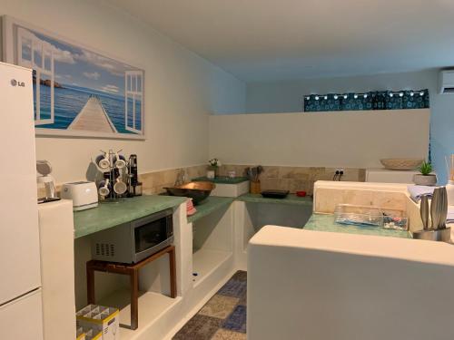 a kitchen with green counter tops and a white refrigerator at Beachside 2 with Private Heated Plunge Pool in Port Douglas