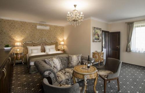 a hotel room with a bed and a couch and a table at Château Šanov in Šanov