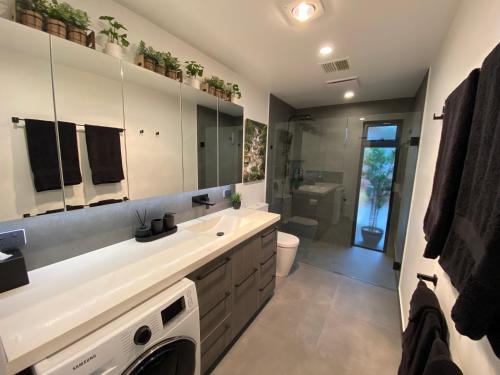 a bathroom with a sink and a washing machine at Altura Apartment Bright in Bright