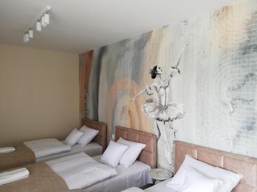 a room with two beds and a painting on the wall at Apartament Latarnik- BIG in Gąski