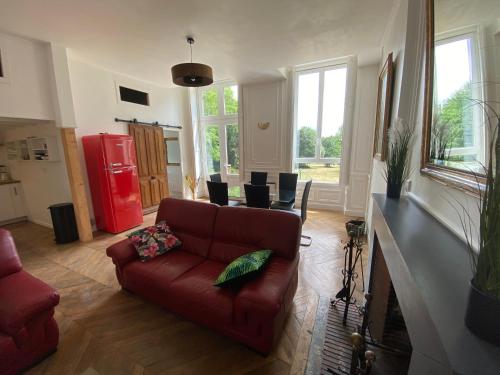 sala de estar con sofá y nevera roja en Le château de Courbouzon, en Courbouzon