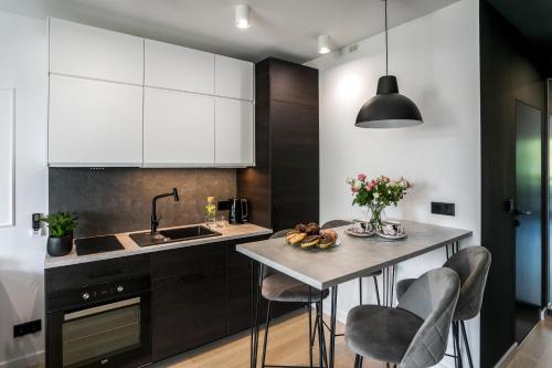 uma cozinha com uma mesa com cadeiras e um lavatório em Barska 69 Apartments na Cracóvia