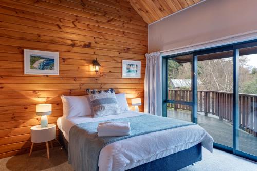 1 dormitorio con cama y ventana grande en Alpine Hide Away - 3 Bedroom, en Closeburn
