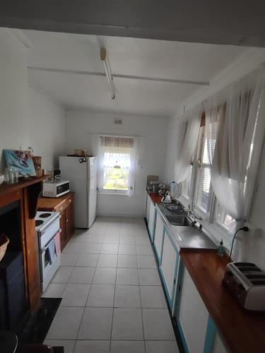 a kitchen with a sink and a refrigerator at Pink Gums Farmstay in Currency Creek