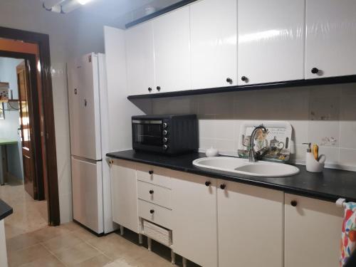 a kitchen with a sink and a refrigerator at Isis Apartment in Antequera