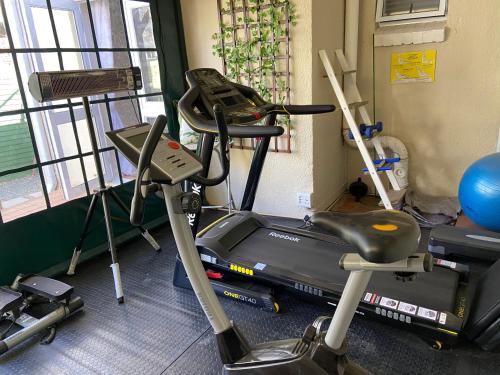 a gym with two exercise bikes and a treadmill at Timeless Bloemfontein in Bloemfontein
