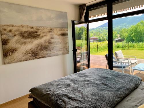 ein Schlafzimmer mit einem Bett und einem großen Fenster in der Unterkunft Teehouse Golf Apartment in Čeladná
