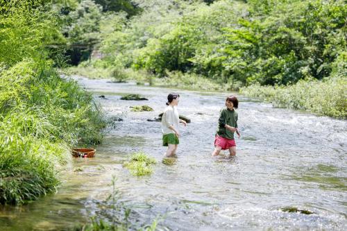 deux enfants traversant un ruisseau dans une rivière dans l'établissement Denpaku Komatsu, à Komatsu