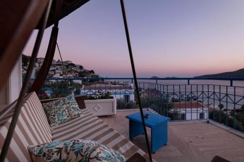 a balcony with a couch and a view of the water at Soothe Hotel in Kalkan