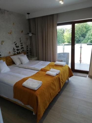 a hotel room with two beds with towels on them at Apartament Latarnik- Yellow in Gąski
