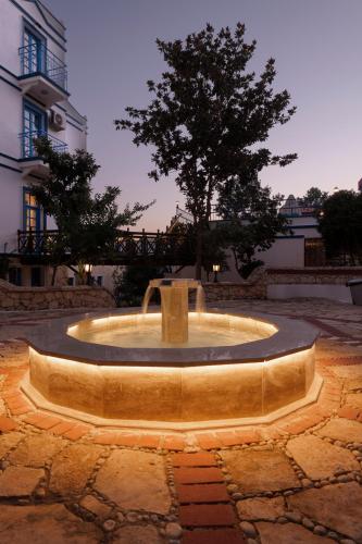 a fountain in the middle of a courtyard with a tree at Soothe Hotel in Kalkan