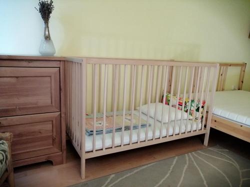 a crib with a pillow in a room at Szőlősi Diófa Vendégház in Balatonszőlős
