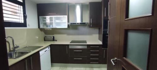 a small kitchen with black cabinets and a sink at Apartamento Numi II in L'Ametlla de Mar