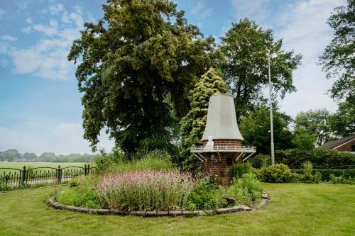 a garden with a bell in the middle at Inner Stillness Wellness Retreat in Albergen
