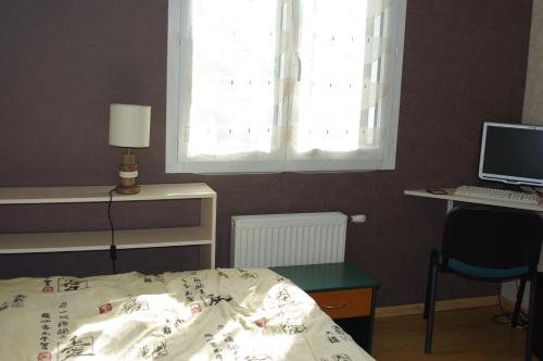 1 dormitorio con 1 cama y escritorio con ordenador en Chambre chez l'habitant en Valence