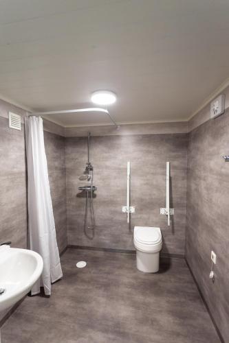 a bathroom with a shower and a toilet and a sink at Maja Camping in Bottnaryd