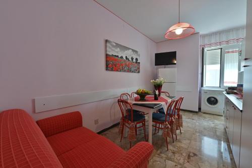 a living room with a red couch and a table at Residence Mariavittoria in Lido di Jesolo