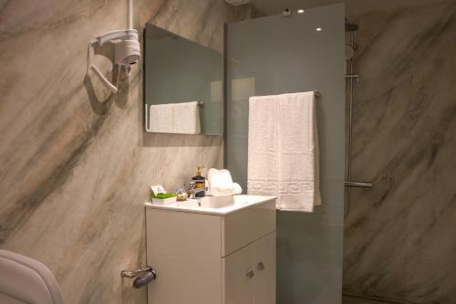 uma casa de banho com um lavatório branco e um espelho. em Danai House em Rodes