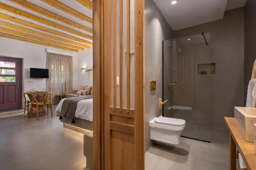 łazienka z toaletą i łóżko w pokoju w obiekcie Kaminos Boutique Hotel w mieście Simi