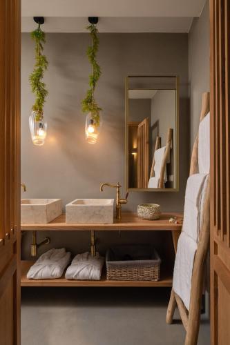 a bathroom with two sinks and a mirror at Kaminos Boutique Hotel in Symi