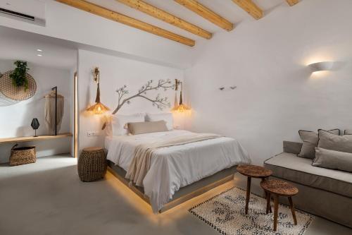 a white bedroom with a bed and a couch at Kaminos Boutique Hotel in Symi