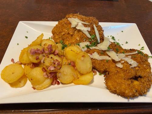 a white plate topped with fried food on a table at Hotel Gasthaus Felseneck in Staufenberg