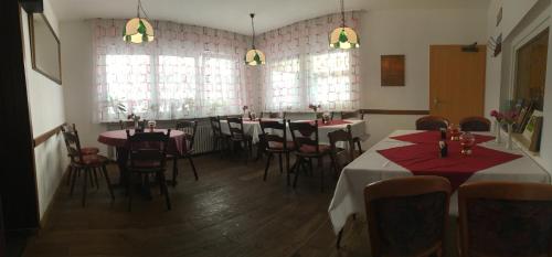 a restaurant with tables and chairs in a room at Hotel Gasthaus Felseneck in Staufenberg