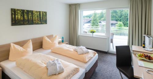 a hotel room with two beds and a balcony at Landhotel Kristall in Bad Marienberg