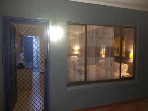 a room with a mirror and a bedroom with a bed at Esk Motel in Esk
