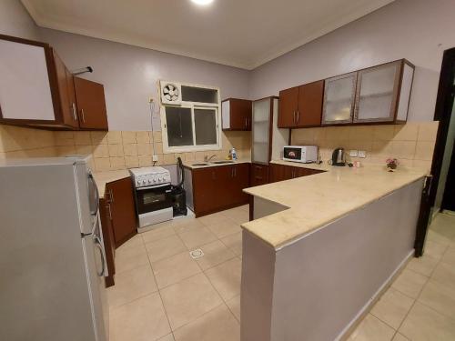 a large kitchen with wooden cabinets and appliances at نزل الشرقي in Abha