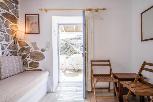 a room with a bed and a table and a door at Κymanemi Folegandros in Agali